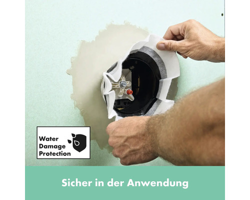 Ein Mann installiert einen Unterputz-Feuchtraumverteiler in einer Wand. Wasserschadensiegel.