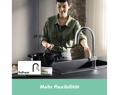 Frau befüllt Kochtopf mit Ausziehbrause an Küchenspüle