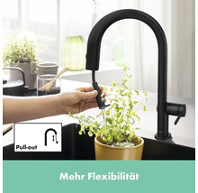 Schwarze Küchenarmatur mit ausziehbarer Brause im Einsatz über einem Topf mit Pflanze.