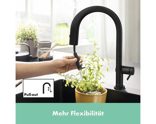 Schwarze Küchenarmatur mit ausziehbarer Brause im Einsatz über einem Topf mit Pflanze.