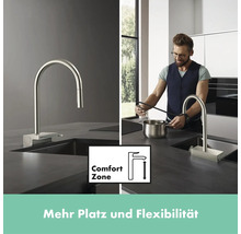 Küchenszene mit Spültischarmatur, ComfortZone Symbol und Mann der einen Topf befüllt.
