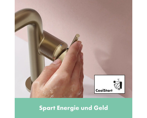 Hand betätigt goldenen Hansgrohe Wasserhahn mit CoolStart Funktion