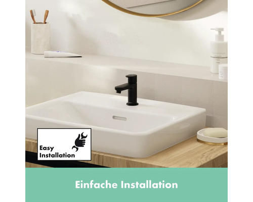 Waschbecken mit schwarzer Armatur im Badezimmer