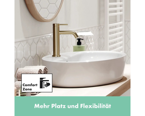 Waschtisch mit goldener Armatur, Handtüchern und Seifenspender