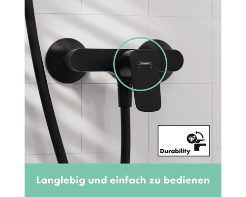 Hansgrohe Logo. Schwarze Duscharmatur mit Brauseschlauch vor hellem Fliesenhintergrund. Symbol für Langlebigkeit.