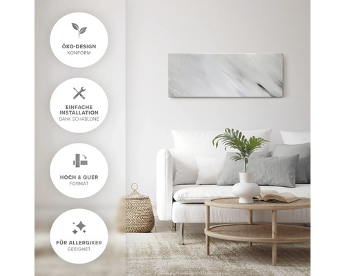 Tableau mural décoratif au-dessus d''un canapé dans un salon lumineux avec des symboles pour l''éco-design, une installation facile, un format portrait et paysage et une compatibilité pour les personnes allergiques