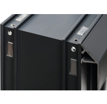 Detailansicht eines schwarzen Aluminiumprofils mit Schraublöchern und Magneten.