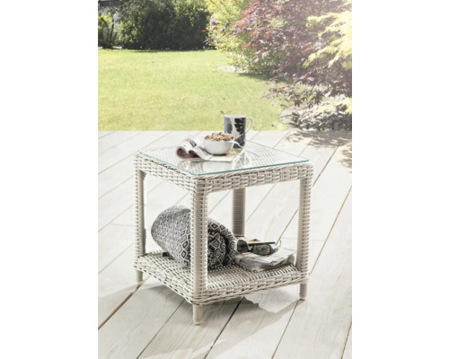 Table de jardin en polyrotin avec plateau en verre, compartiment de rangement et décoration dans le jardin