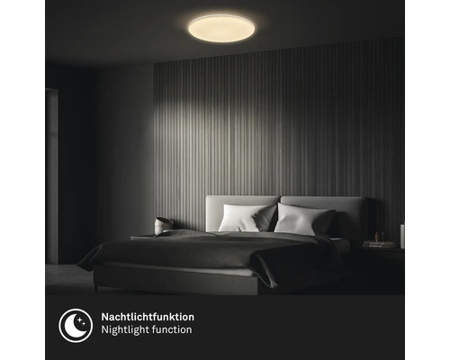 Schlafzimmer mit einem an der Decke montierten, runden Deckenlicht mit Nachtlichtfunktion