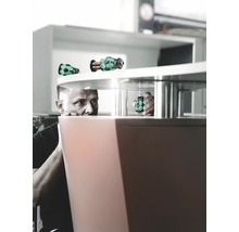 Un homme fixe un meuble avec un tournevis.