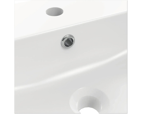 Detailansicht eines weißen Waschbeckens mit Hahnloch und Überlauf