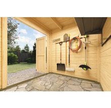 Abri de jardin spacieux avec outils et portes en bois ouvertes, vue sur un jardin verdoyant.