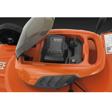 Gros plan du compartiment à batterie d''une tondeuse à gazon avec une batterie Husqvarna insérée