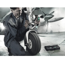 Ein Mechaniker repariert das Fahrwerk eines Flugzeugs mit Schraubendrehern und einer Werkzeugtasche.