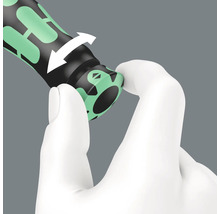 Gros plan d''une main tournant le manche d''un tournevis pour activer la fonction de couple.