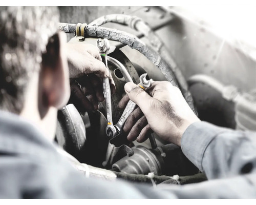 Mechaniker mit Schraubenschlüsseln bei der Reparatur eines Motors