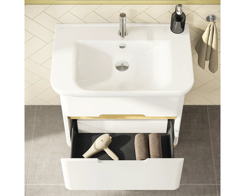 Draufsicht auf ein Badezimmerwaschbecken mit geöffneter Schublade, in der sich ein Fön und Handtücher befinden