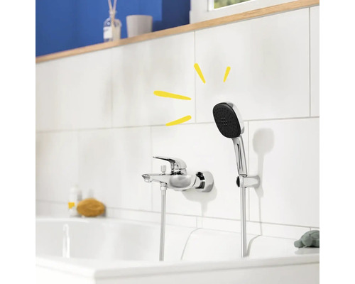 Photo d''une salle de bains avec une robinetterie et une douchette sur un mur carrelé blanc