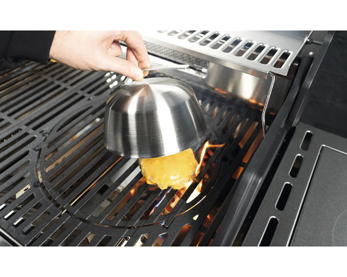 Käseburger wird auf einem Grill unter einer Schmelzglocke zubereitet