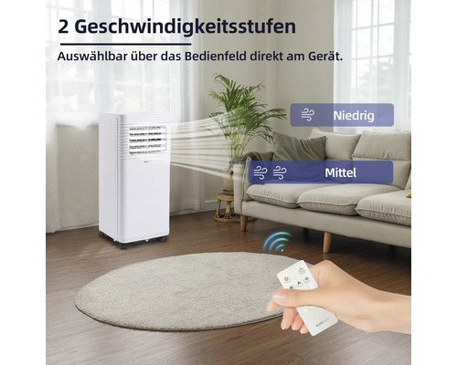 Mobiles Klimagerät mit zwei Geschwindigkeitsstufen und Fernbedienung in einem Wohnzimmer.