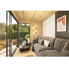 Aménagement intérieur lumineux d'une maison de jardin avec canapé, table en verre et porte coulissante