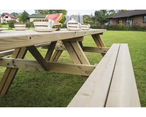 Holzbiertischgarnitur mit Geschirr im Garten