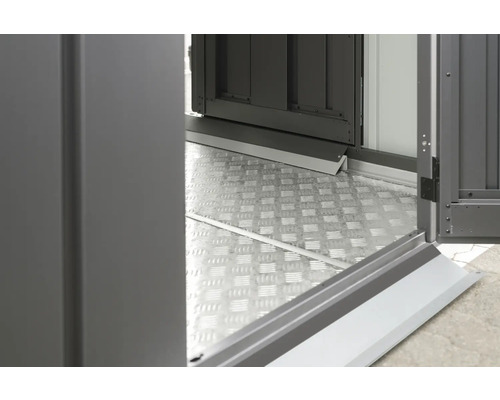 Vue détaillée d''une plaque de sol métallique et d''une porte ouverte d''une cabane de jardin