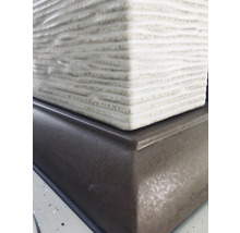 Detailaufnahme einer Tischleuchte mit braunem Sockel und Lampenschirm mit horizontaler Rillenstruktur