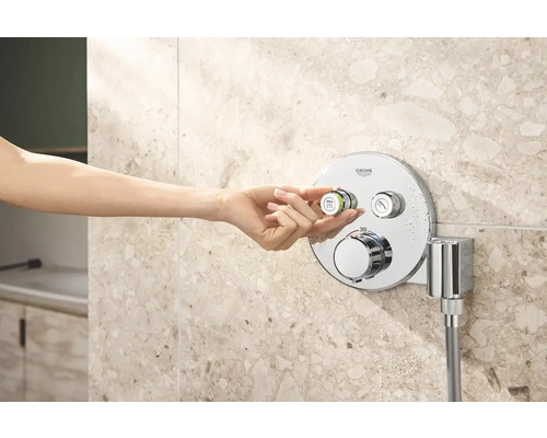 Frauenhand bedient Grohe Duscharmatur im Badezimmer