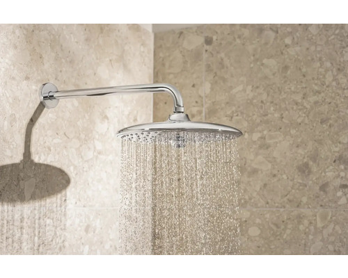 Eine verchromte Duschbrause mit laufendem Wasser ist an der Wand befestigt.