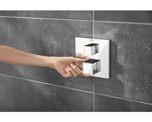 Femme actionnant un robinet Grohe dans une salle de bain