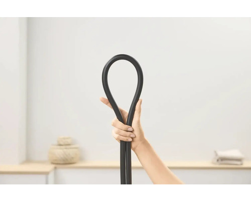 Une main tenant un tuyau noir flexible