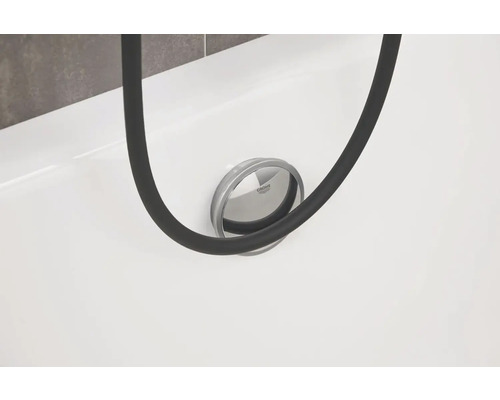 Détail d''une baignoire avec garniture de vidange Grohe et un flexible de douche