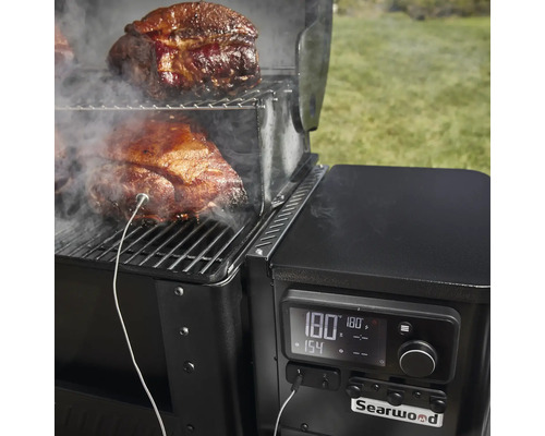 Vue détaillée d''un grill Searwood avec de la viande sur la grille et une sonde de température pour surveiller la cuisson.