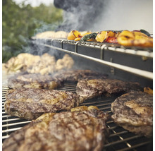Grill mit Steaks und Gemüse auf dem Rost