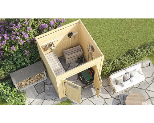 Scène de jardin avec abri de jardin, étagère à bois, robot tondeuse et coin salon sur une surface pavée