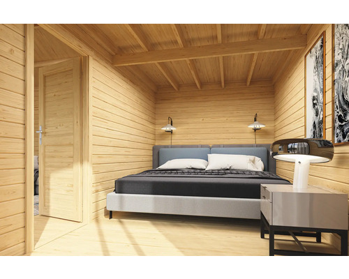 Intérieur d'une maison en bois avec lit et porte