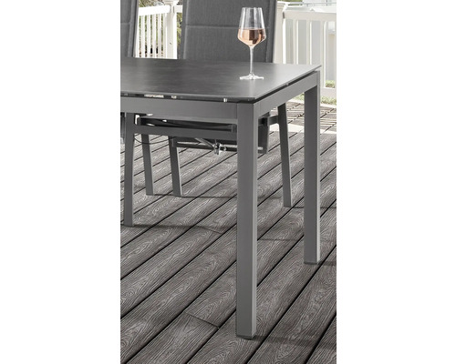 Vue détaillée d''une table de jardin avec boisson sur une terrasse en bois.