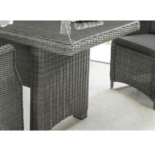 Gros plan d''une table en rotin avec un plateau en verre et une chaise en rotin avec un coussin, idéal pour le jardin