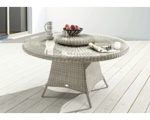 Runder Gartentisch aus Rattan mit Glasplatte und Dekorationen auf einer Terrasse