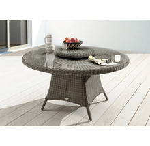 Table de jardin avec plateau en verre, structure en rotin et objets de décoration