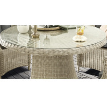 Vue détaillée d''une table de jardin ronde avec plateau en verre et structure en rotin