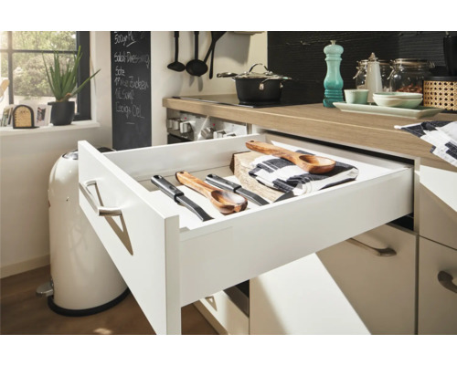 Tiroir de cuisine ouvert avec cuillères à mélanger en bois et couteaux