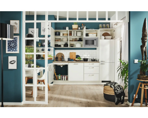 Moderne Küche mit weißen Schränken, Regalen und Mikrowelle, ergänzt durch dekorative Elemente und Pflanzen.