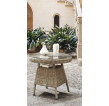 Rattan Beistelltisch mit Glasplatte, Büchern, Vase und Getränk im Gartenbereich