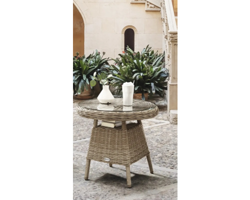 Rattan Beistelltisch mit Glasplatte, Büchern, Vase und Getränk im Gartenbereich