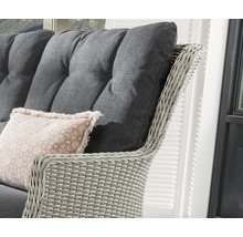 Gros plan d''un fauteuil en rotin avec coussins gris et coussin décoratif