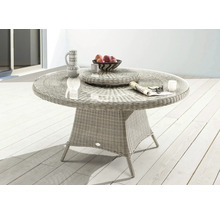 Table de jardin ronde en rotin avec plateau en verre, décorée de vaisselle et de fruits