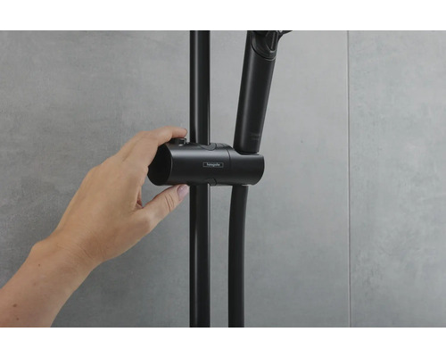 Hand die eine schwarze Duschstange mit Handbrause verstellt