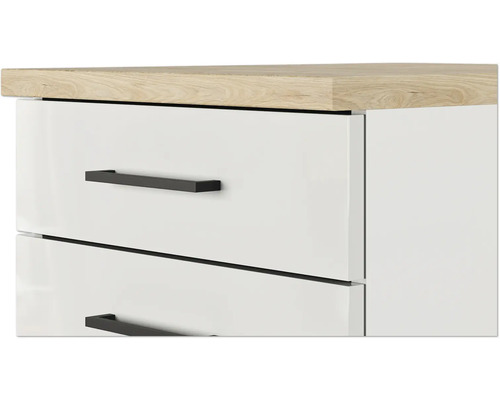 Detailansicht eines weißen Schubladenelements mit Holzplatte und schwarzen Griffen